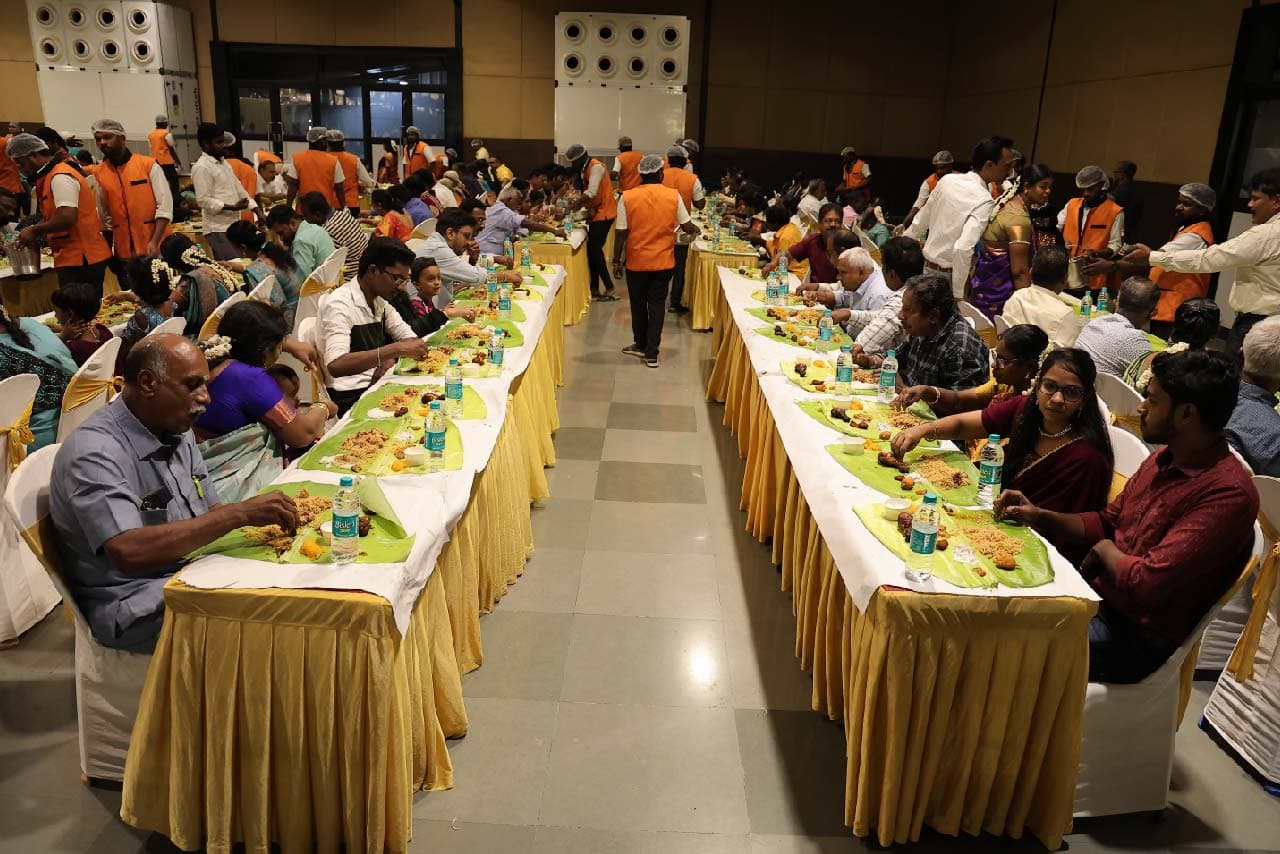 Guests dining on traditional banana leaf at a large event